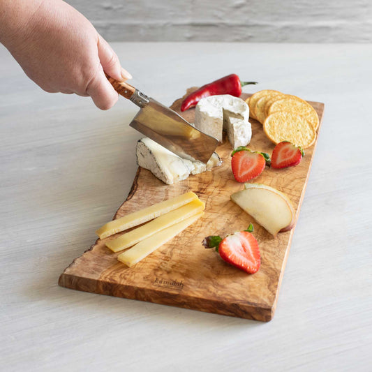 Cutting cheese on olive wood cheese board