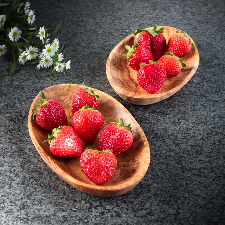 Oval bowl made from olive wood for serving strawberries