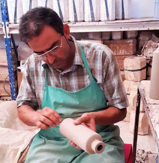 man crafting oil bottle in the Jamailah pottery