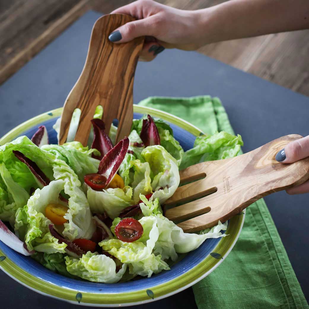 Showing how to scoop salad with salad forks handcrafted from olive wood